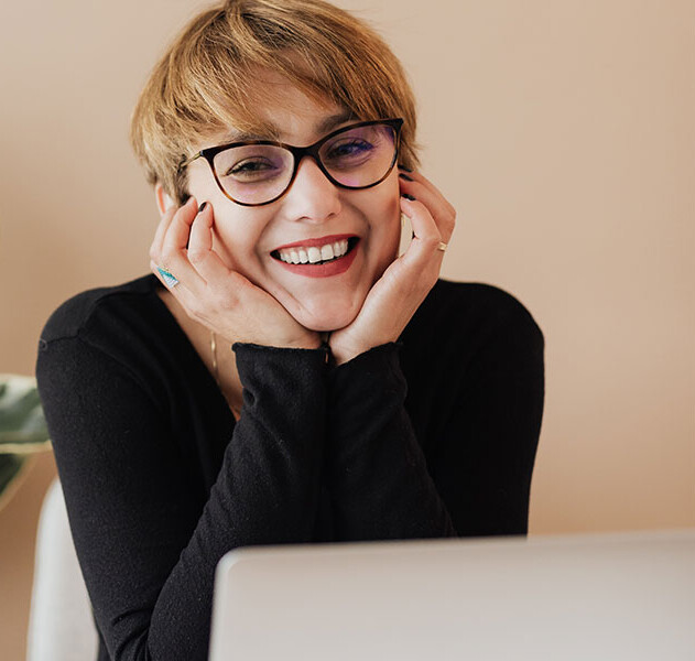 Woman Sitting Behind Laptop Smiling